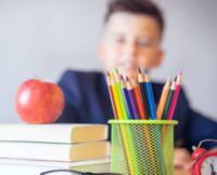 School child with books an apple school stationery/equipment | About us | Avatar Learning Center | Online STEM Tutoring
