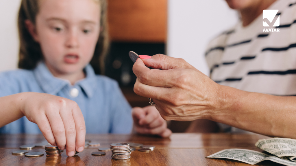 A child and an adult are sitting at a table, counting coins together. The child, focused on the task, is stacking coins while the adult is holding a coin and pointing to it. There are some dollar bills and more coins scattered on the table. The image conveys a moment of learning and financial education between the child and the adult.